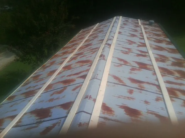 Rusted metal roof panels with new wood purlins before replacement — Storm Damage Roof Repair in Cumming by Roofing Brothers