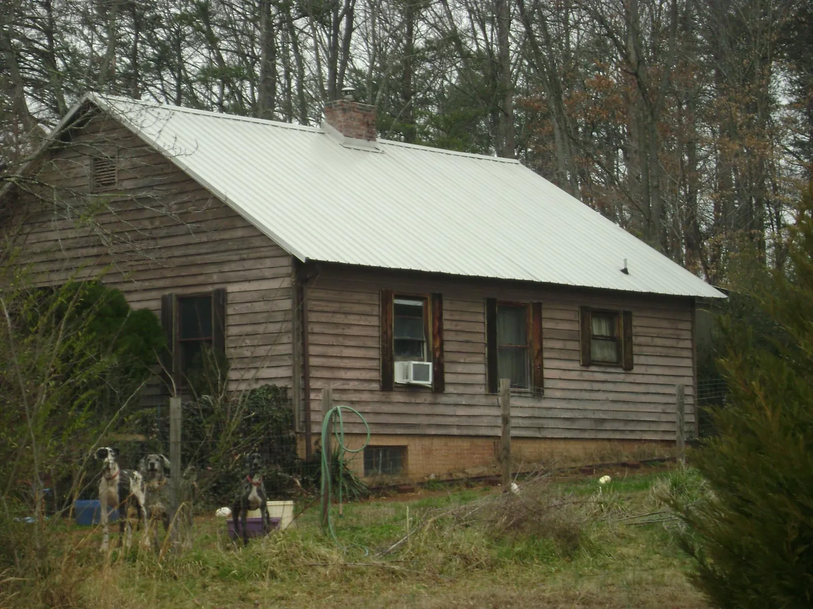 White metal roof on an old wood sided farmhouse, from a Asphalt Shingle Roof Repair job in Cumming